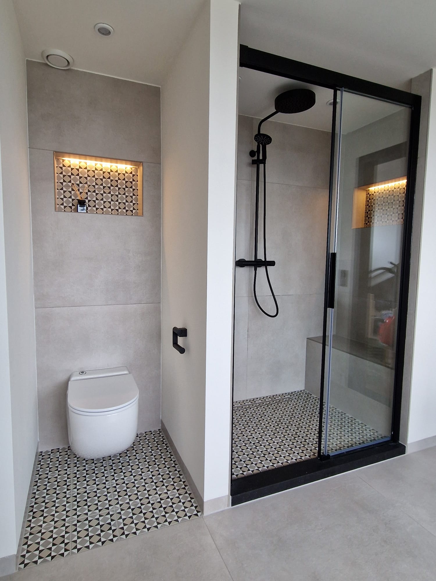 Toiletruimte en inloopdouche met zwart frame, vloer van zwart-wit patroontegels